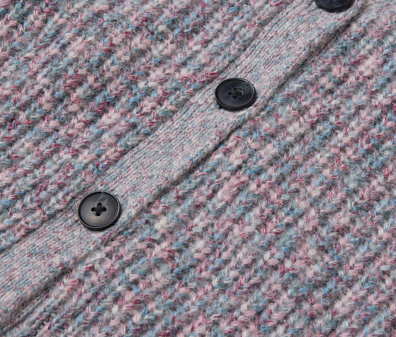 Gros plan sur une veste en maille pour enfant avec de la laine certifiée RWS, avec des boutons.