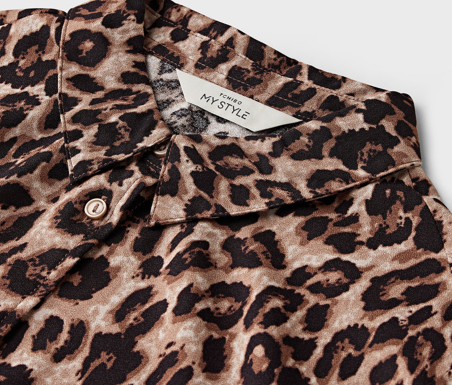 Détail d'une chemise à imprimé léopard marron et noir, col visible.