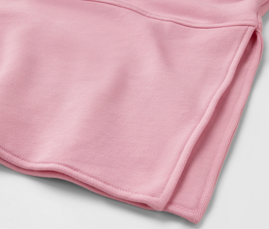 Détail d'un sweat-shirt long à capuche rose.