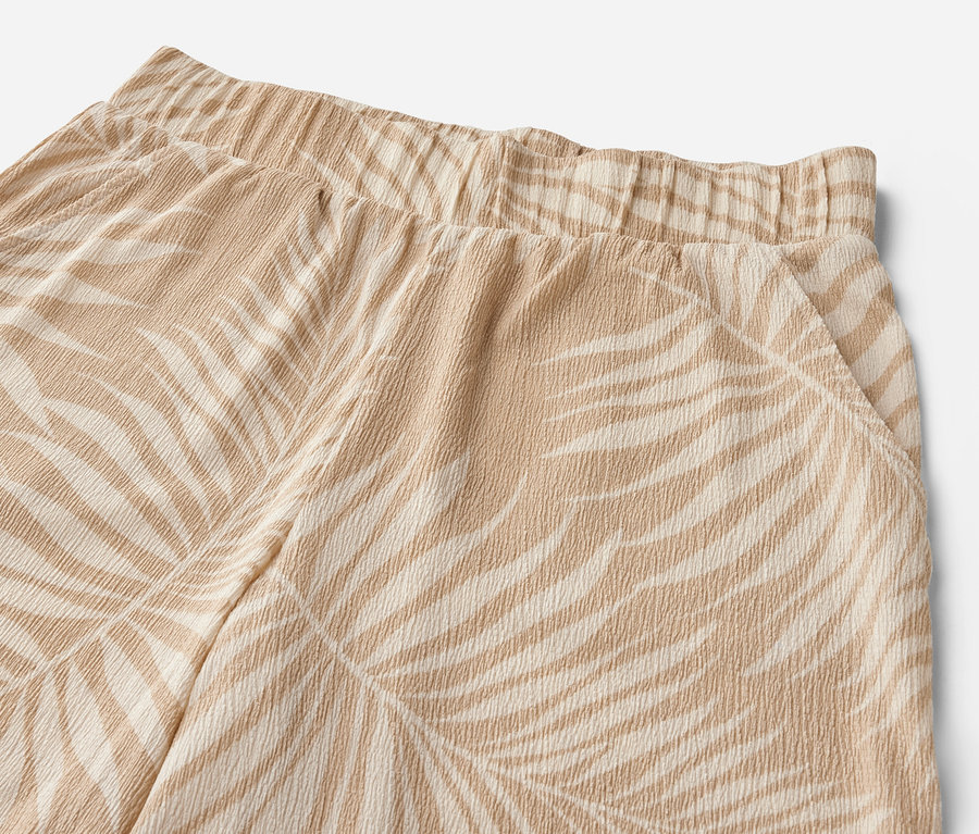 Détail d'un pantalon palazzo structuré avec imprimé intégral.