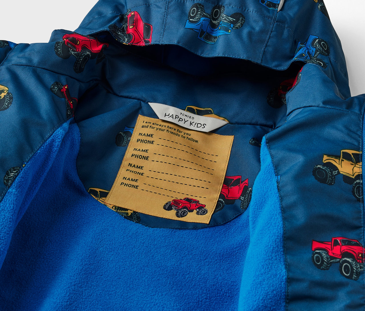 Détail d'une veste imperméable thermique pour enfants avec un motif de monster trucks.