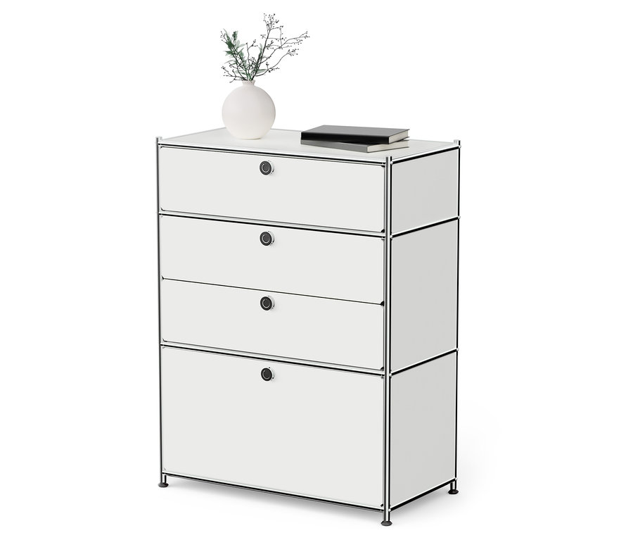 Commode métallique blanche « CN3 » avec 3 tiroirs et un abattant. Un vase avec une plante et un livre sont posés sur la commode.