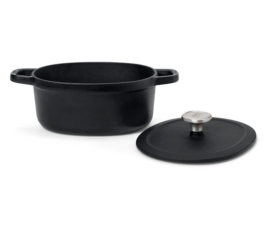 Une cocotte noire en fonte avec un couvercle sur un fond blanc.