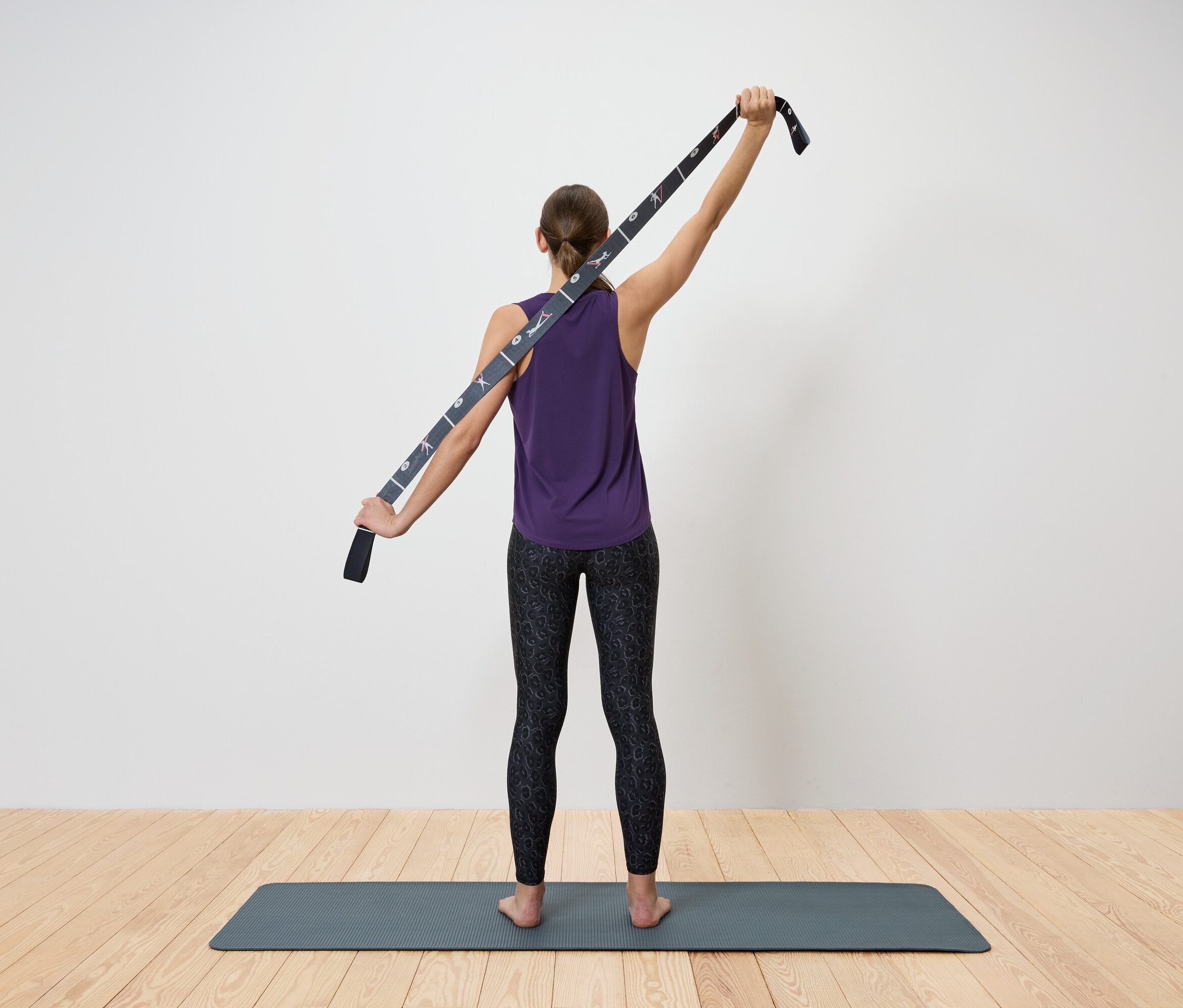 Femme étirant le haut du corps avec une sangle de yoga.