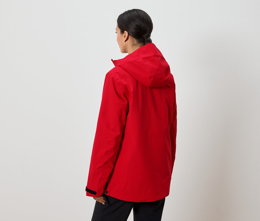 Une femme, vue de dos, porte une veste rouge à capuche.