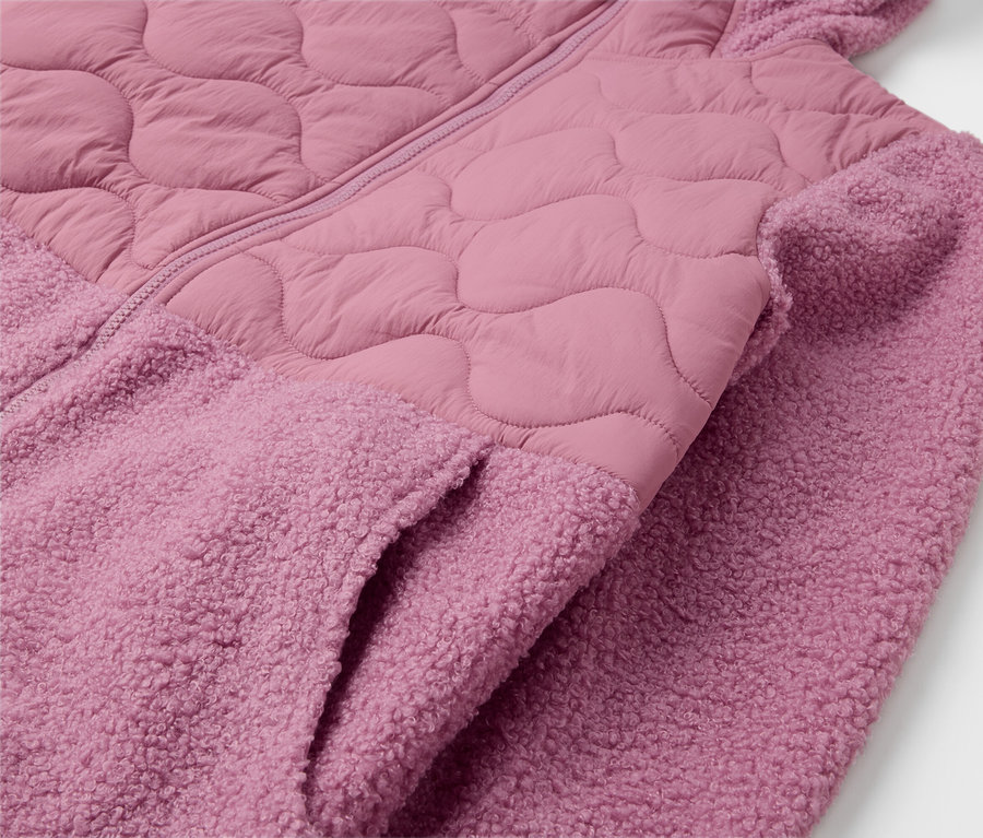 Gros plan sur une veste à capuche rose avec une poche.