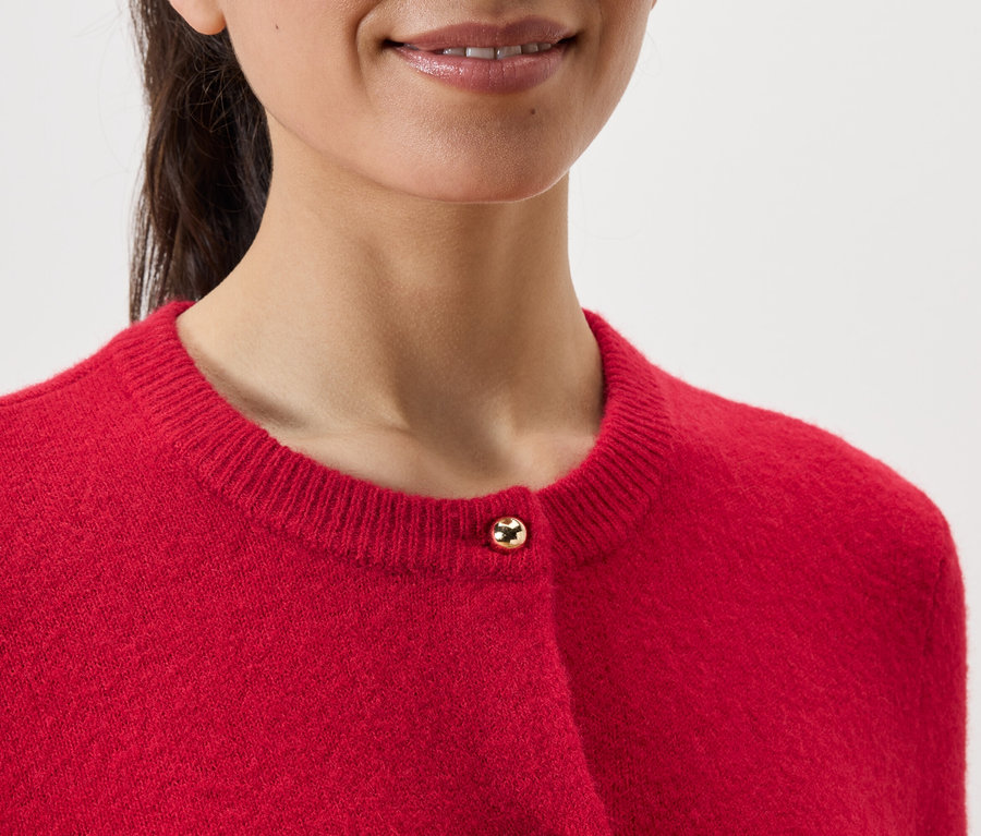 Gros plan d'une femme portant un cardigan rouge.