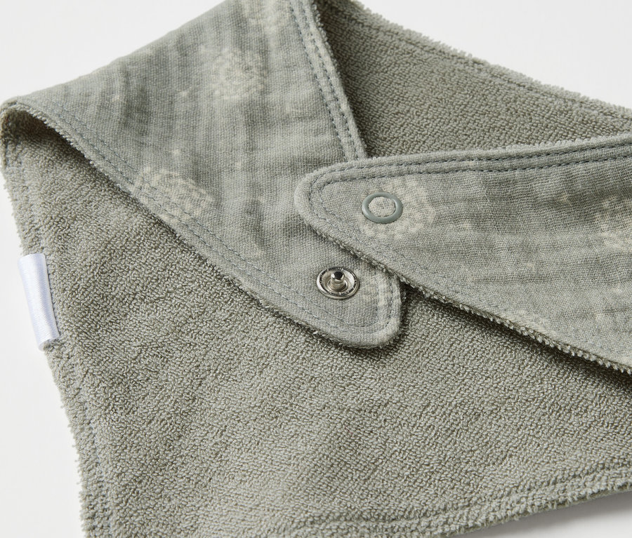 Gros plan d'un foulard en mousseline pour bébé avec des boutons-pression.