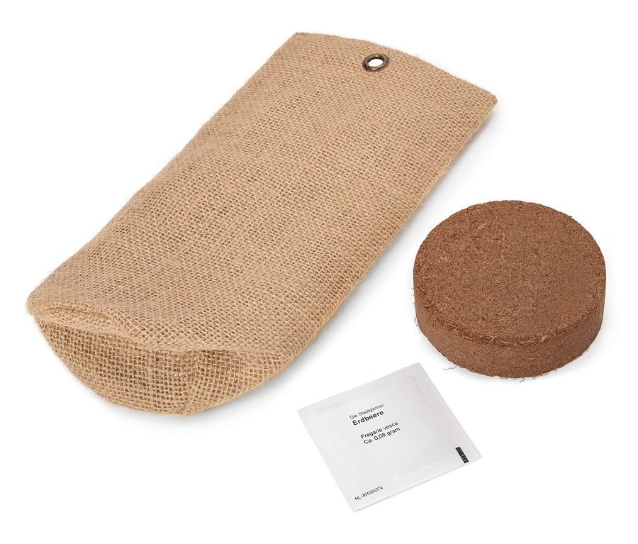 Un sac en jute marron est posé à côté d'une tablette ronde marron et d'un petit paquet blanc.