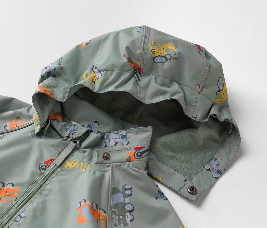 Gros plan d'une veste pour enfant vert olive à capuche, imprimée de camions de chantier.
