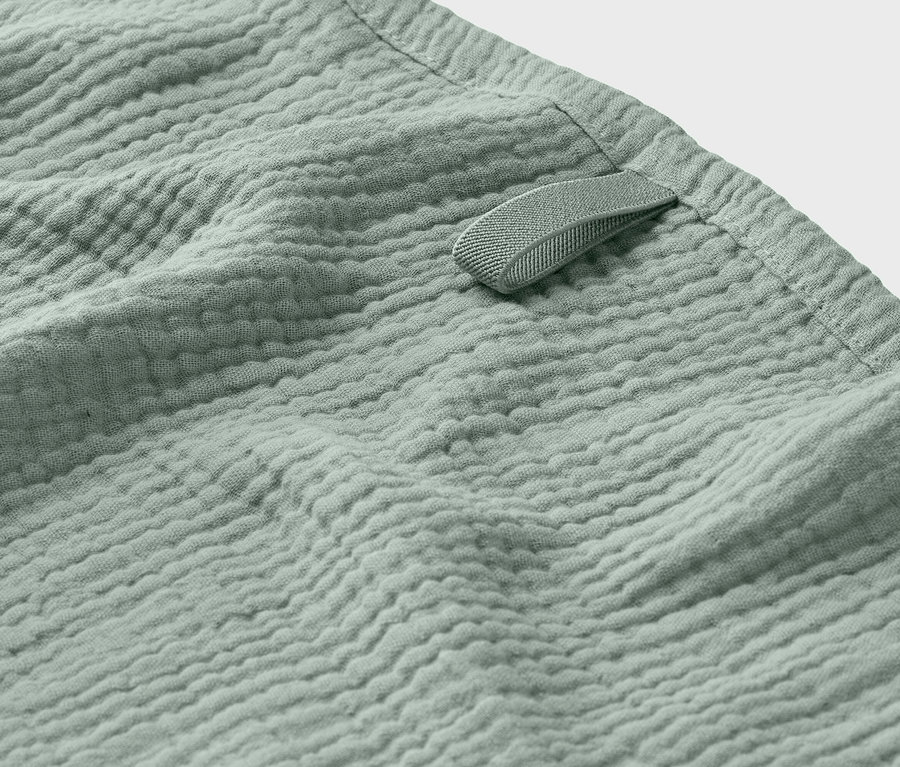 Gros plan sur un tissu en mousseline vert clair avec une petite boucle.