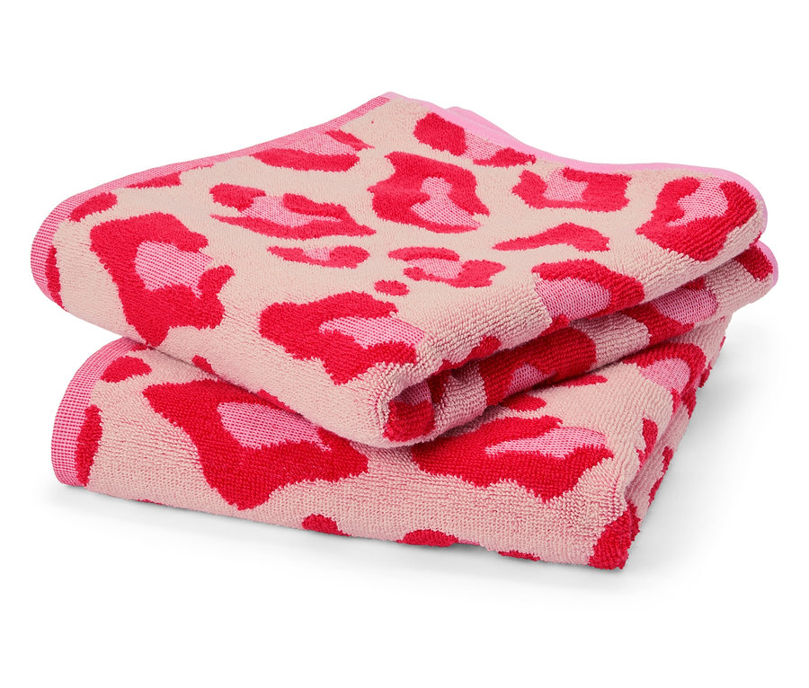 Deux serviettes roses pliées avec un motif léopard sont posées l'une sur l'autre.