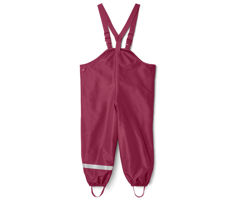 Un pantalon de pluie bordeaux à bretelles est posé sur un fond blanc. Des bandes réfléchissantes sont présentes sur les jambes.