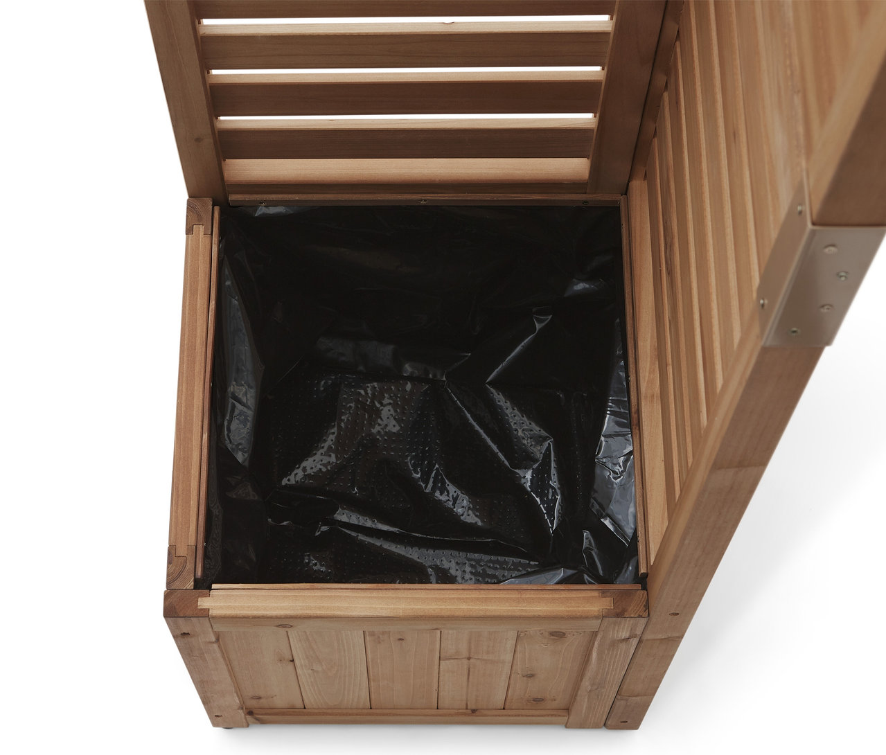 Vue à l'intérieur d'une jardinière en bois avec une doublure en plastique noir.