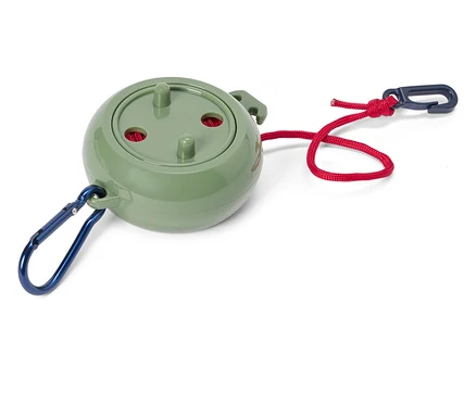 Un objet rond vert avec une corde rouge et des mousquetons bleus aux deux extrémités est posé sur un fond blanc.