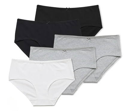 Cinq culottes en coton blanc, gris et noir sont posées les unes sur les autres.