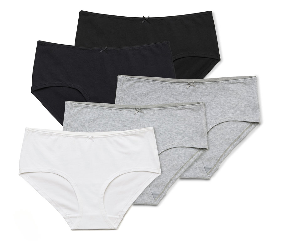 Cinq culottes en coton blanc, gris et noir sont posées les unes sur les autres.