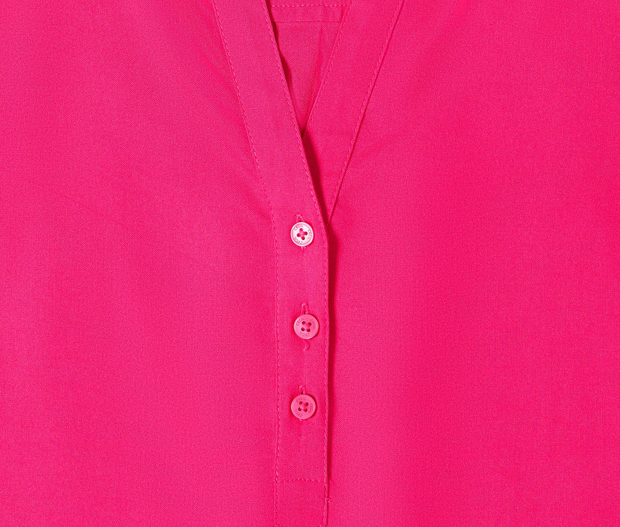 Gros plan sur le chemisier tunique rose vif CECIL avec patte de boutonnage et col.