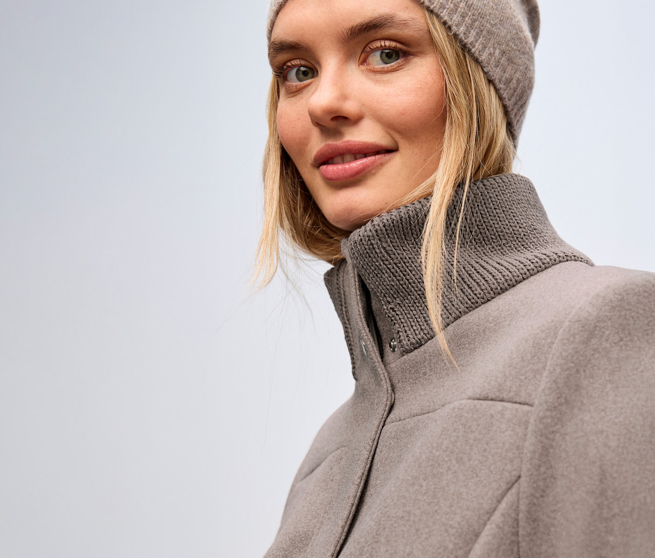 Femme portant un manteau court Street One et un bonnet.