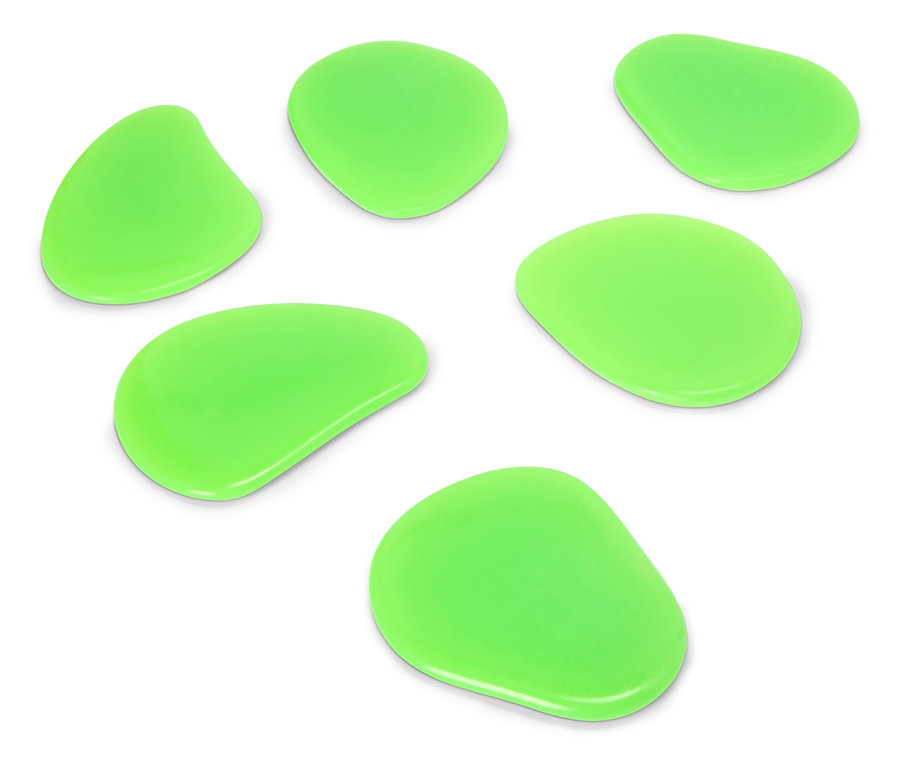 Sept pierres vertes de formes irrégulières disposées sur une surface blanche.