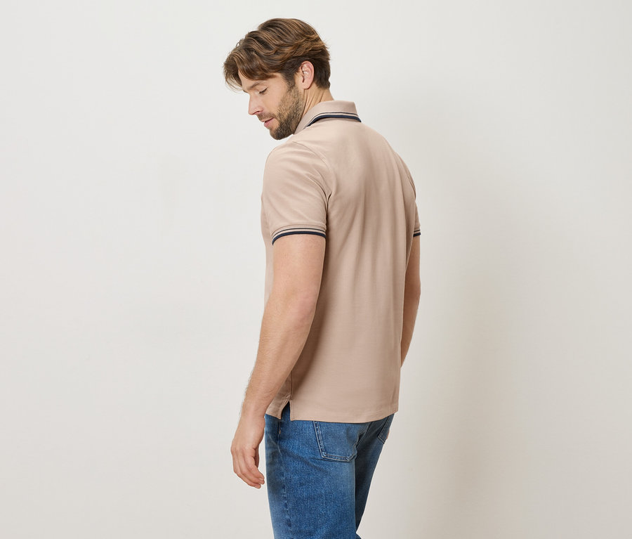 Homme de dos en polo beige et jean