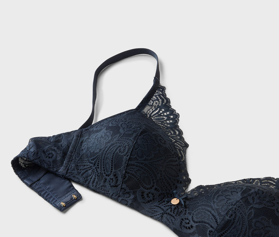 Gros plan d'un soutien-gorge en dentelle bleu marine avec bretelle réglable.