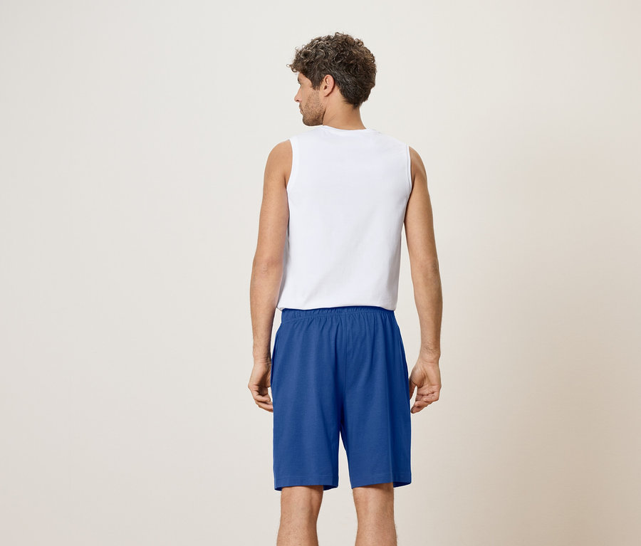 Vue arrière d'un homme portant un débardeur blanc et un short bleu.