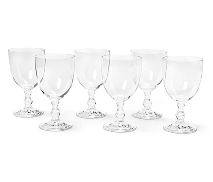 Sept verres à vin vides disposés sur deux rangées sur fond blanc.