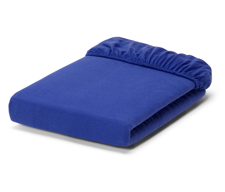 Un drap-housse bleu plié sur un fond blanc.