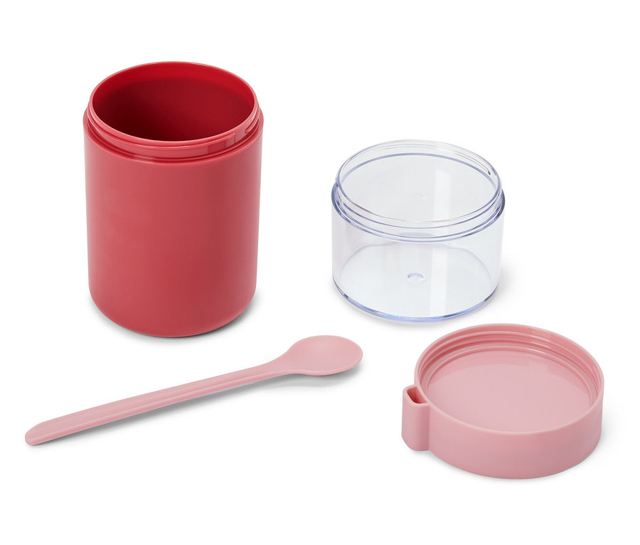 Un récipient alimentaire rouge, un récipient transparent, une cuillère rose clair et un couvercle rose clair sont disposés sur un fond blanc. Le récipient rouge est ouvert, à côté d'un récipient transparent ouvert. Une cuillère rose est posée en dessous, et un couvercle rose est placé à droite.