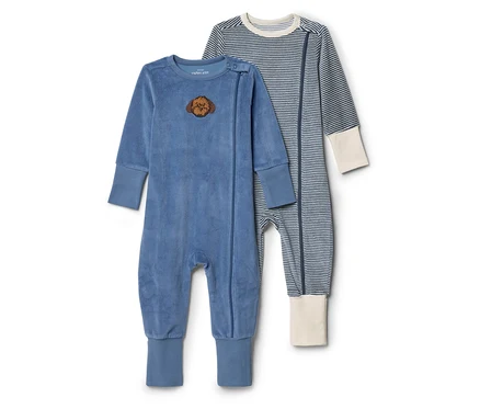 Deux grenouillères pour bébé posées côte à côte. L'une est bleue et veloutée avec un écusson tête de lion, l'autre est rayée bleu et blanc avec des poignets crème.