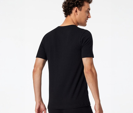 Homme de dos, légèrement tourné sur le côté, portant un t-shirt SCHIESSER noir et des sous-vêtements noirs.
