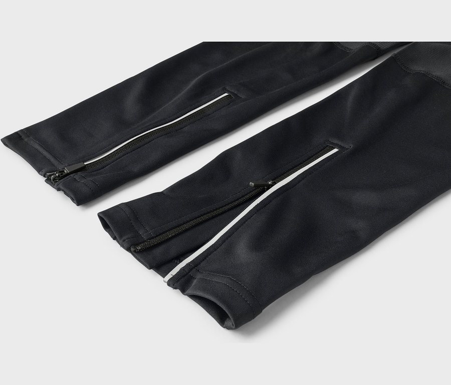 Deux jambes de pantalon noires, chacune avec une bande blanche et une fermeture éclair le long du côté près de la cheville.