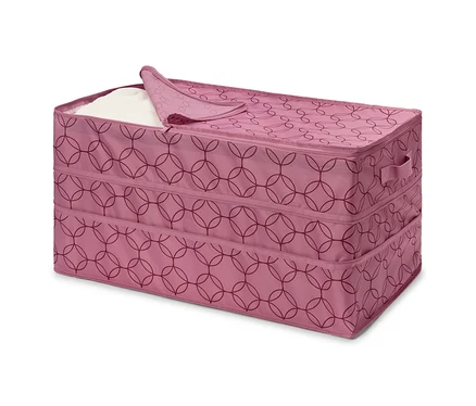 Boîte en tissu rose avec fermeture éclair et motif géométrique, partiellement remplie de tissu blanc.