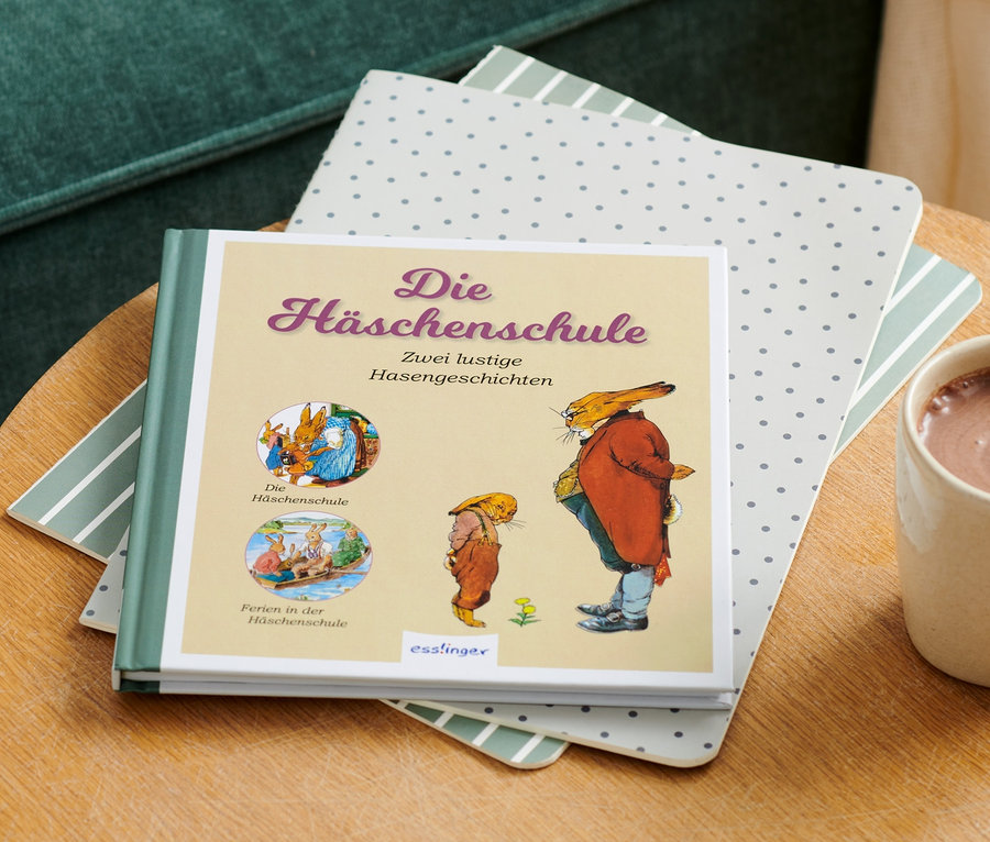Le livre « Die Häschenschule » est posé sur une table à côté d'une tasse de chocolat chaud.