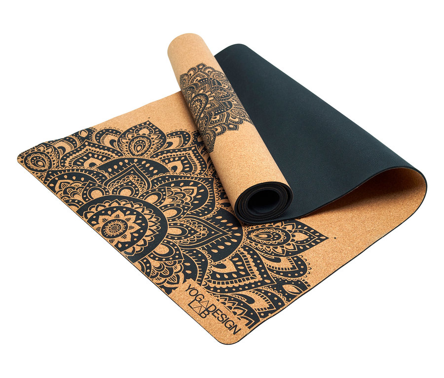 Un tapis de yoga en liège partiellement enroulé avec un motif floral noir.