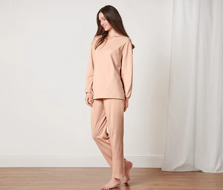 Femme debout en pyjama dans une pièce.