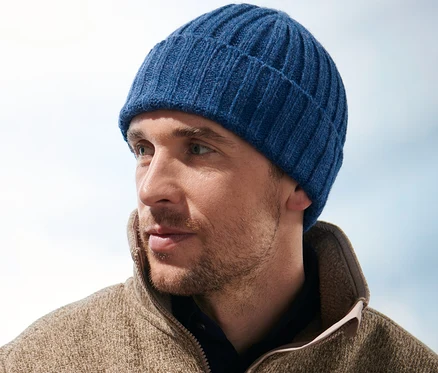 Un homme portant un bonnet en maille regarde vers la droite.