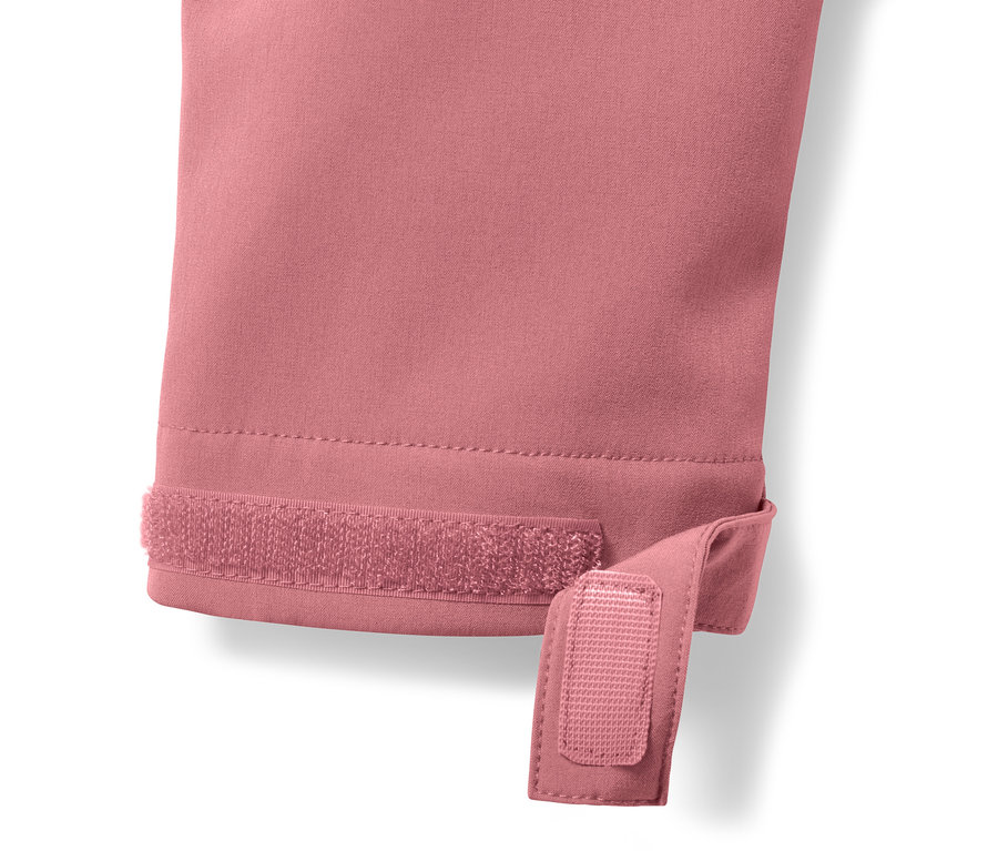 Détail d'un manteau softshell rose avec une fermeture velcro sur la manche.