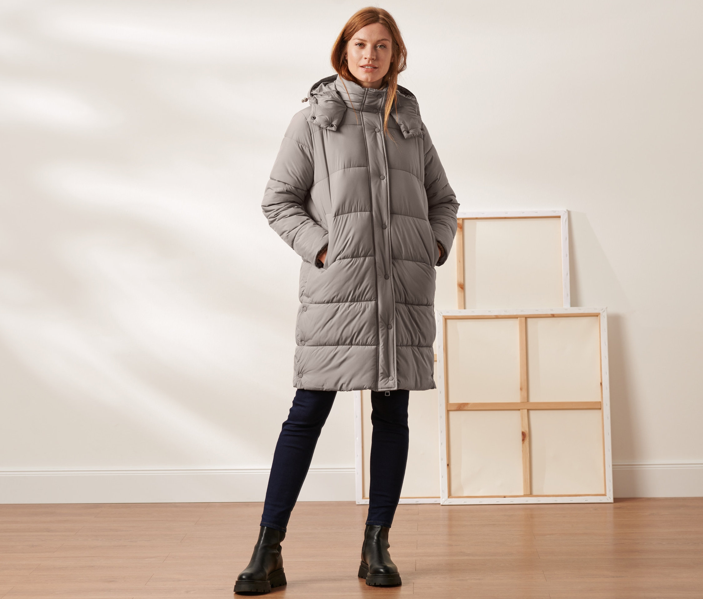 Femme portant un manteau matelassé à capuche taupe.