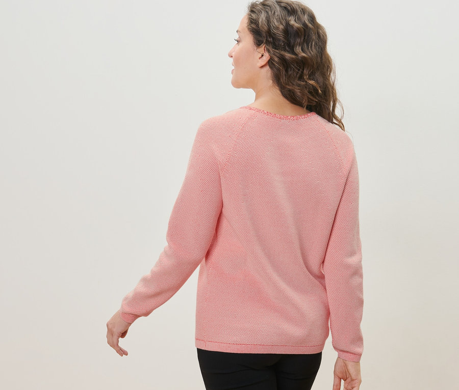 Femme regardant par-dessus son épaule portant un pull en maille.