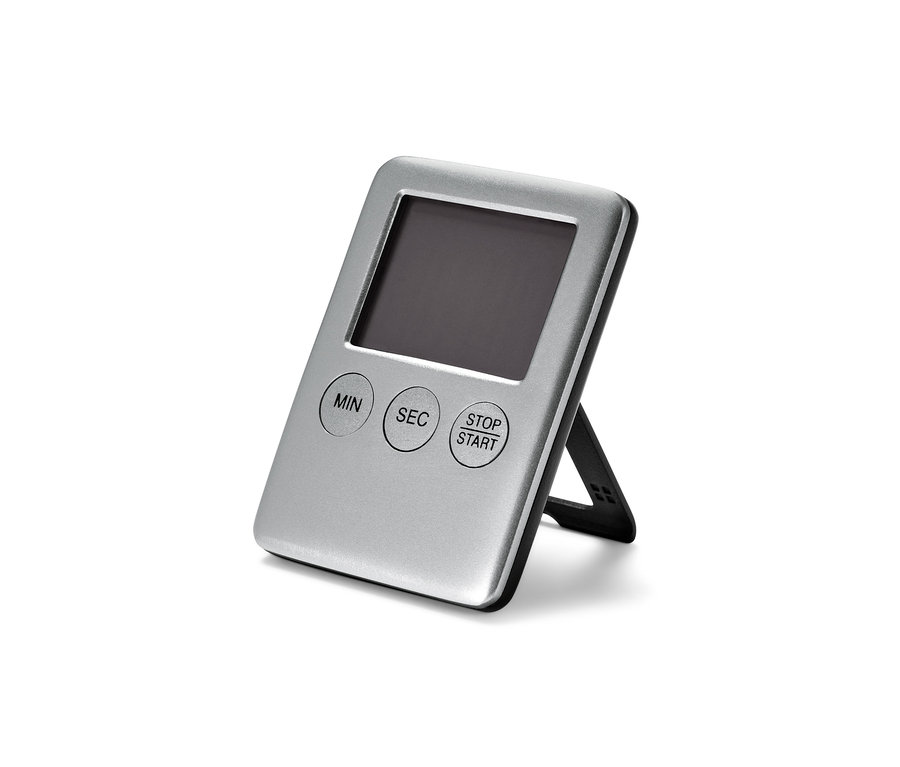 Un minuteur numérique argenté posé sur une surface blanche.