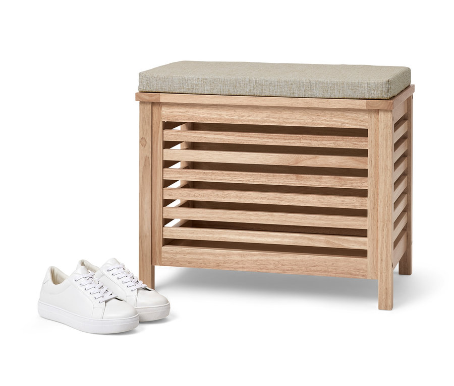 Coffre en bois massif avec coussin et baskets blanches.