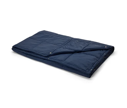 Une couverture de voyage ultralégère bleu marine pliée.