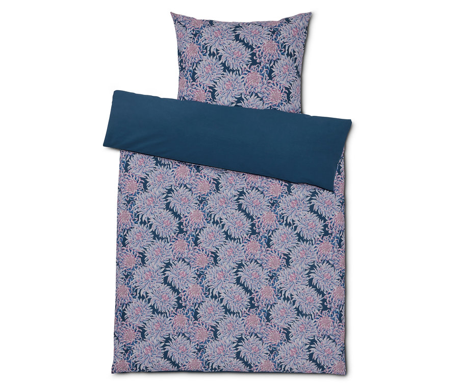 Literie avec motif floral et bordure bleu foncé.