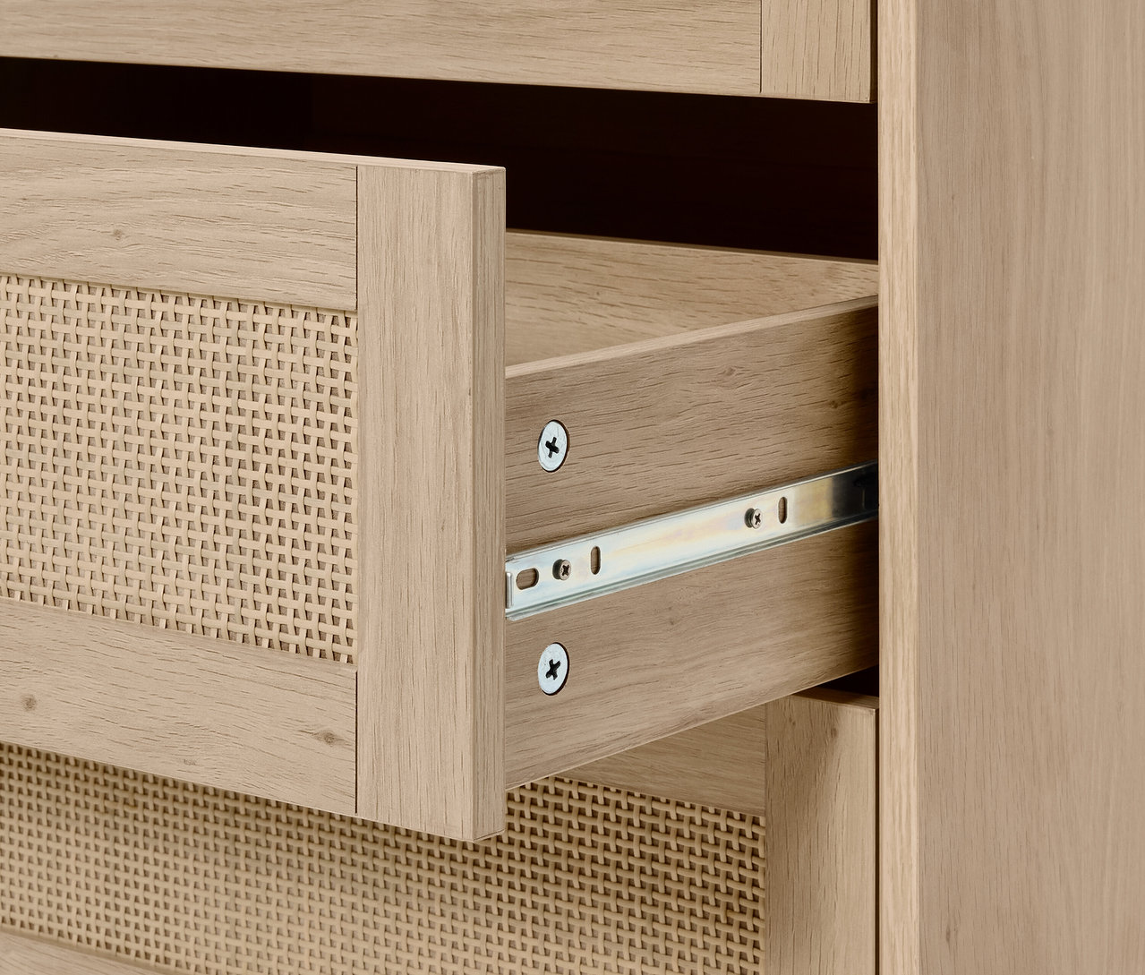 Détail d'une commode avec un tiroir en osier ouvert.