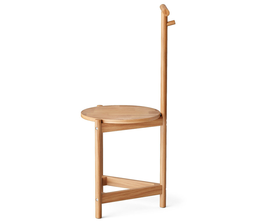 Vue latérale d'une petite table en bois avec un plateau rond et un haut dossier.