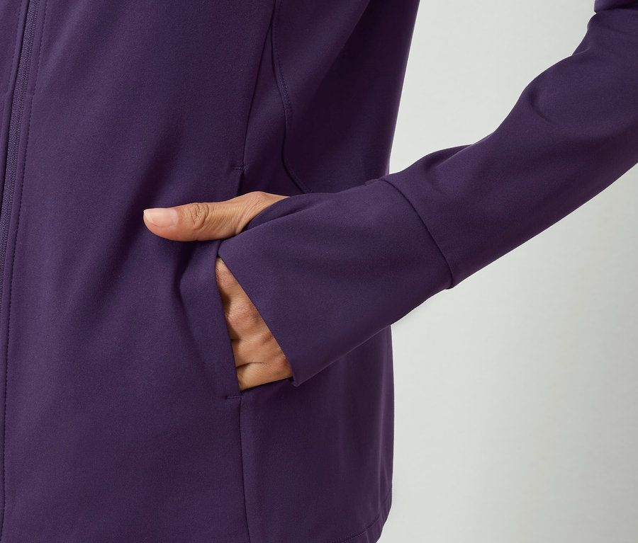 Main dans la poche d'une veste violette.