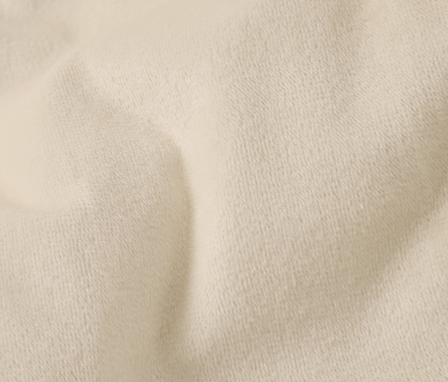 Gros plan d'un tissu couleur crème avec une texture fine et des plis.
