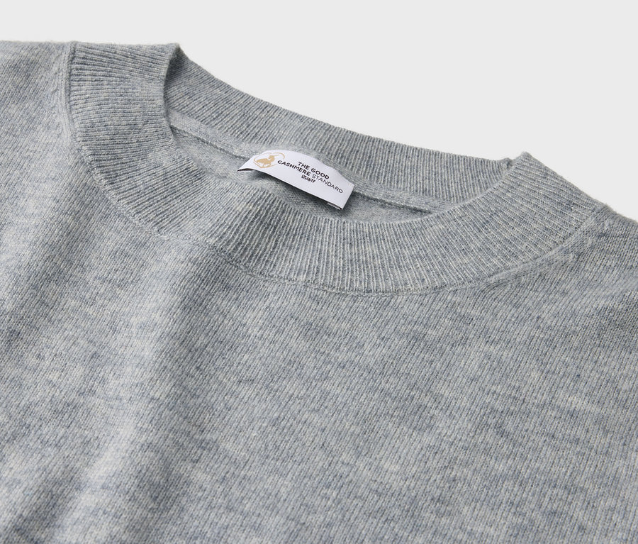 Gros plan d'un pull en cachemire gris à col rond avec une étiquette.